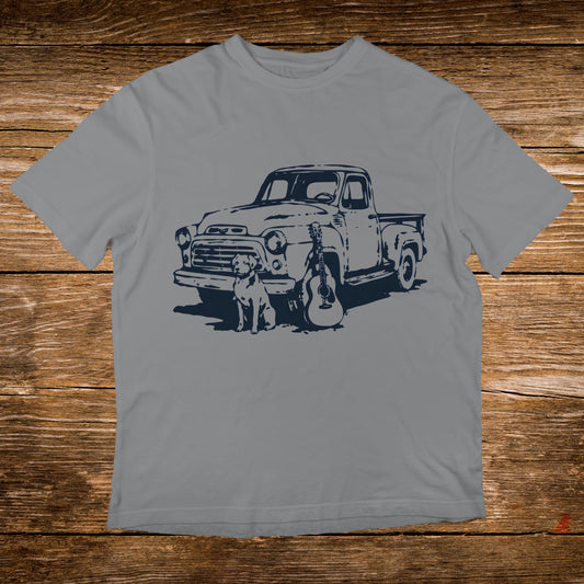 Gray t-shirt graphic with a vintage truck, dog, and guitar illustration.