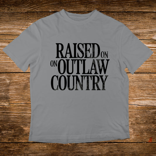 Grey t-shirt with black text that reads "Raised on Outlaw Country".