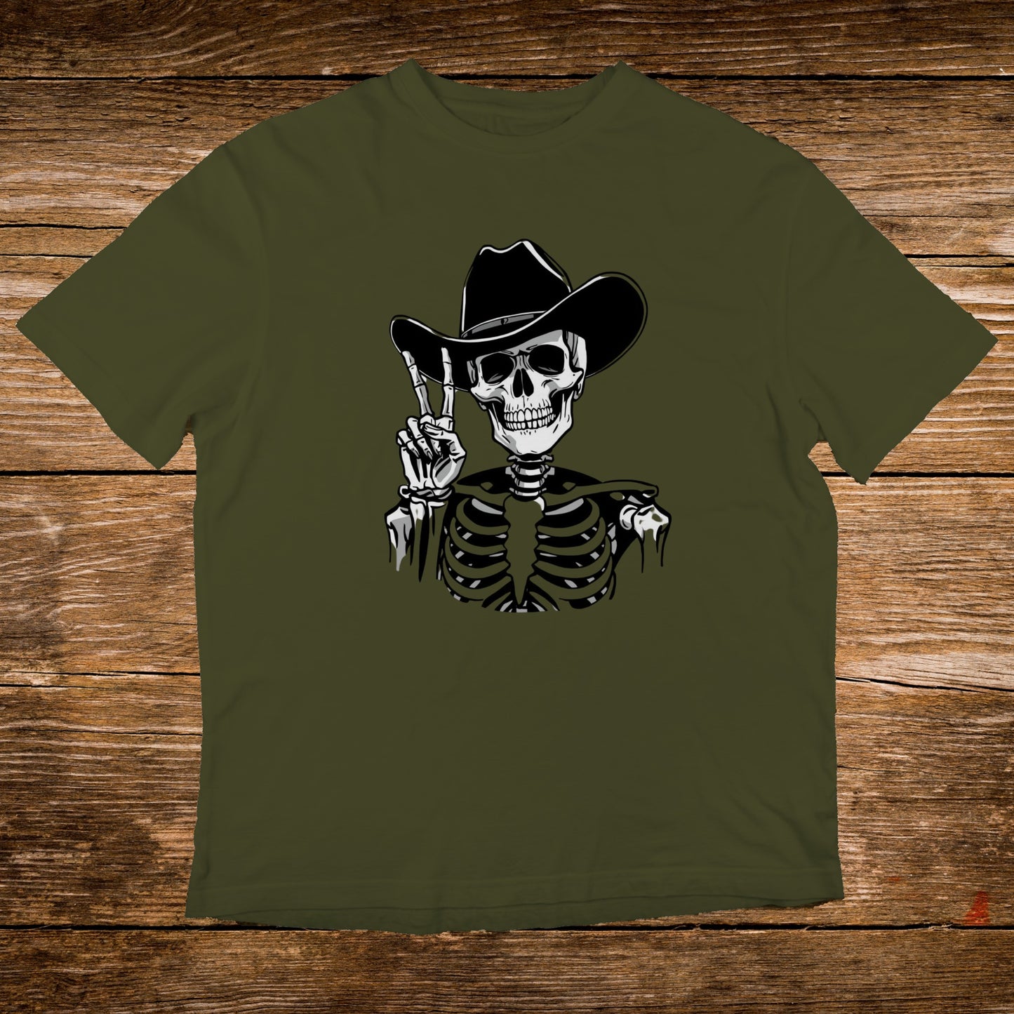 Skeleton wearing a cowboy hat, giving peace sign on olive green t-shirt.