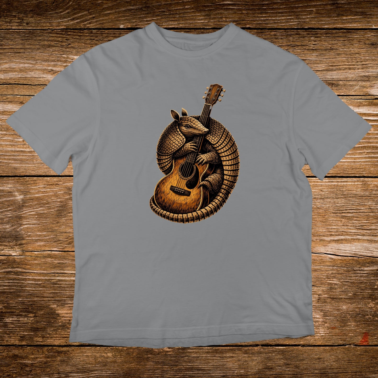 Armadillo playing an acoustic guitar on a grey t-shirt.
