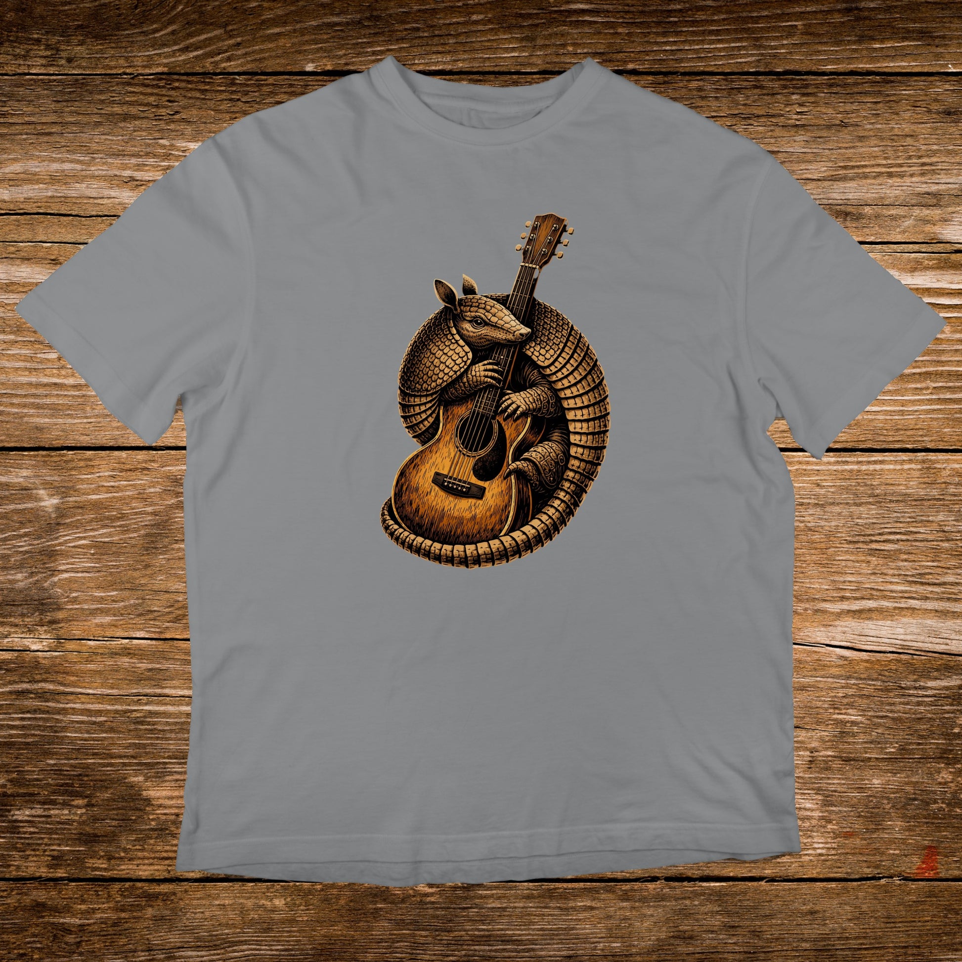 Armadillo playing an acoustic guitar on a grey t-shirt.