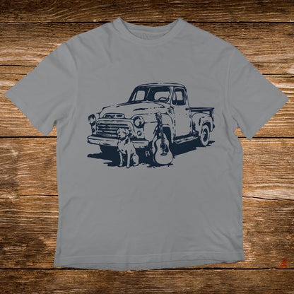Gray t-shirt graphic with a vintage truck, dog, and guitar illustration.