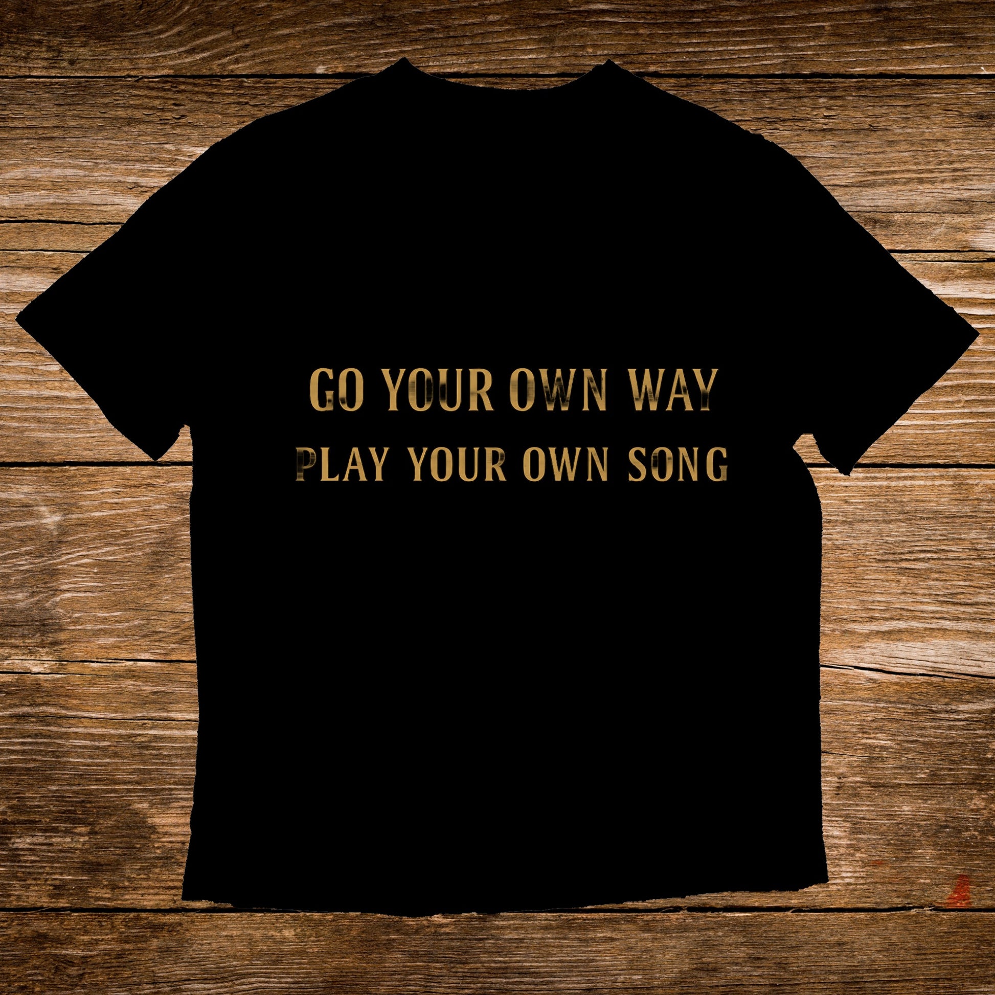 Black t-shirt with gold text: "GO YOUR OWN WAY PLAY YOUR OWN SONG"