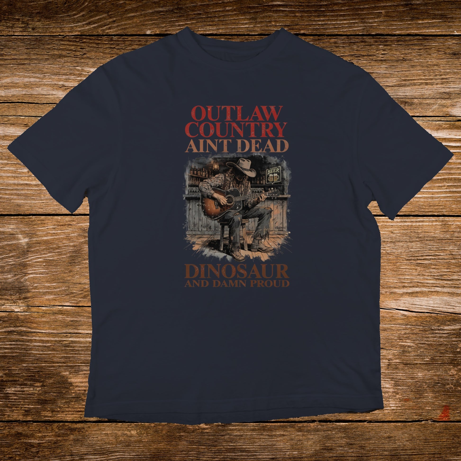 Outlaw Country Ain't Dead Dinosaur and Damn Proud t-shirt with cowboy playing guitar.