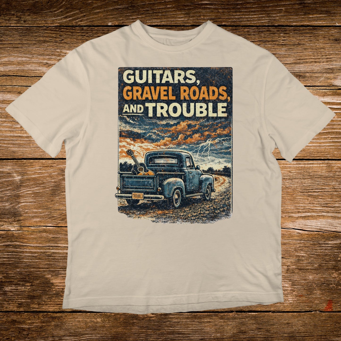 Truck with guitars on rough road under stormy sky, text: GUITARS, GRAVEL AND TROUBLE.