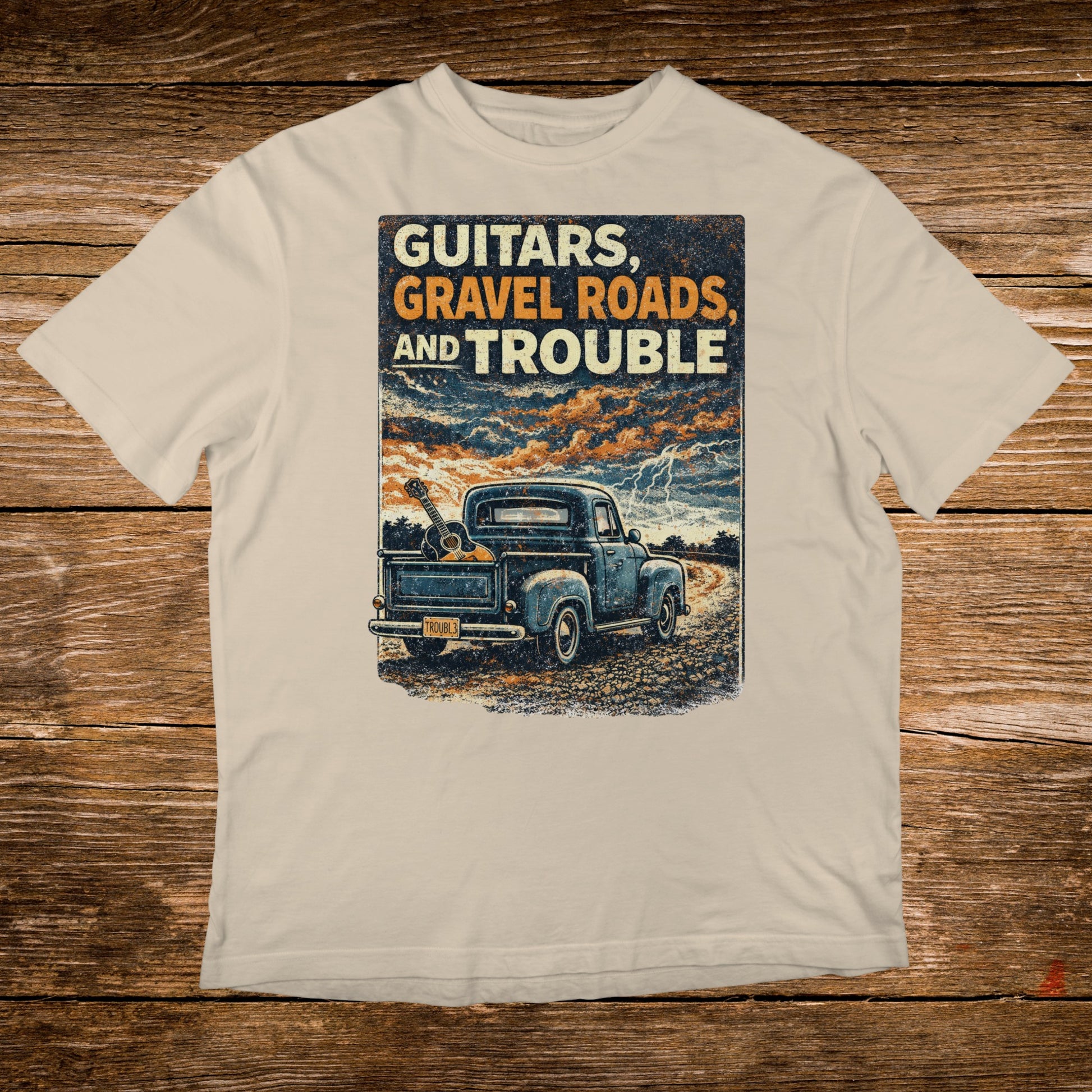 Truck with guitars on rough road under stormy sky, text: GUITARS, GRAVEL AND TROUBLE.
