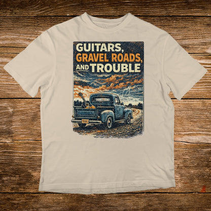 Truck with guitars on rough road under stormy sky, text: GUITARS, GRAVEL AND TROUBLE.