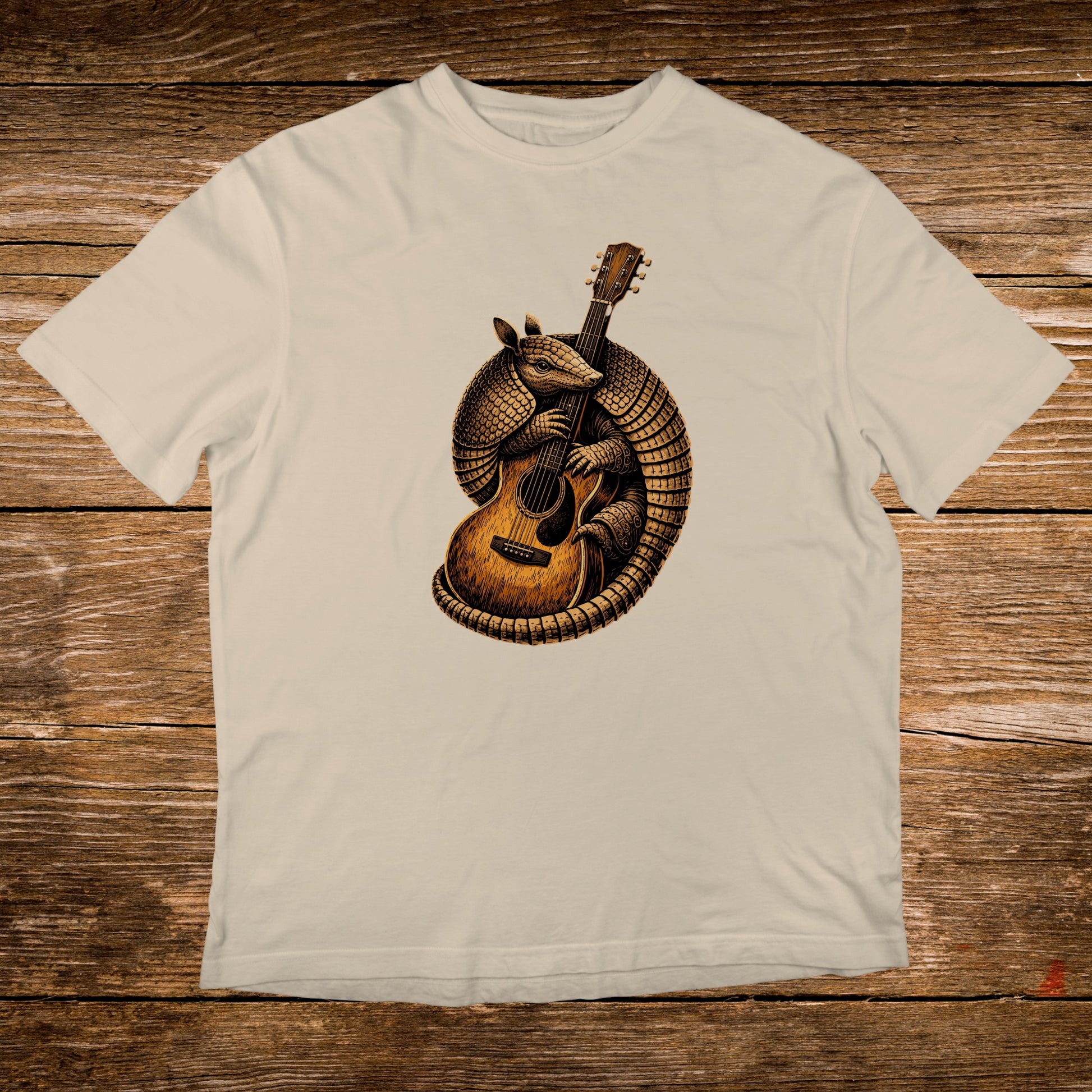 Illustration of an armadillo playing an acoustic guitar on a cream t-shirt.