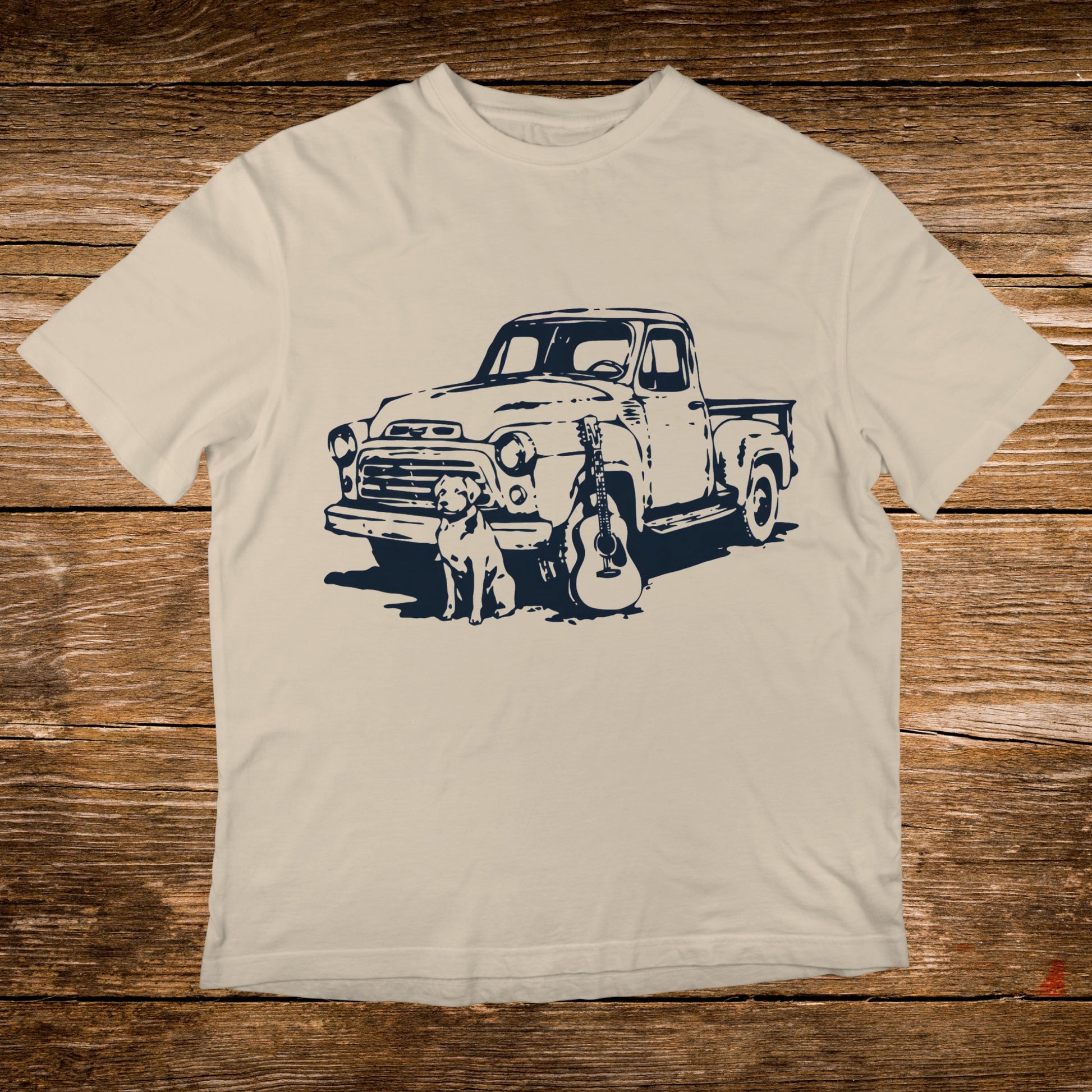 Cream t-shirt with navy graphic of vintage truck, dog, and guitar.