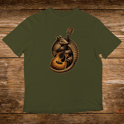Armadillo playing an acoustic guitar on a dark green t-shirt.