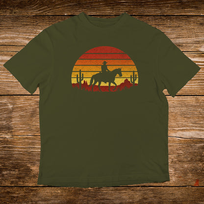 Olive t-shirt with a sunset silhouette of a cowboy on horseback.