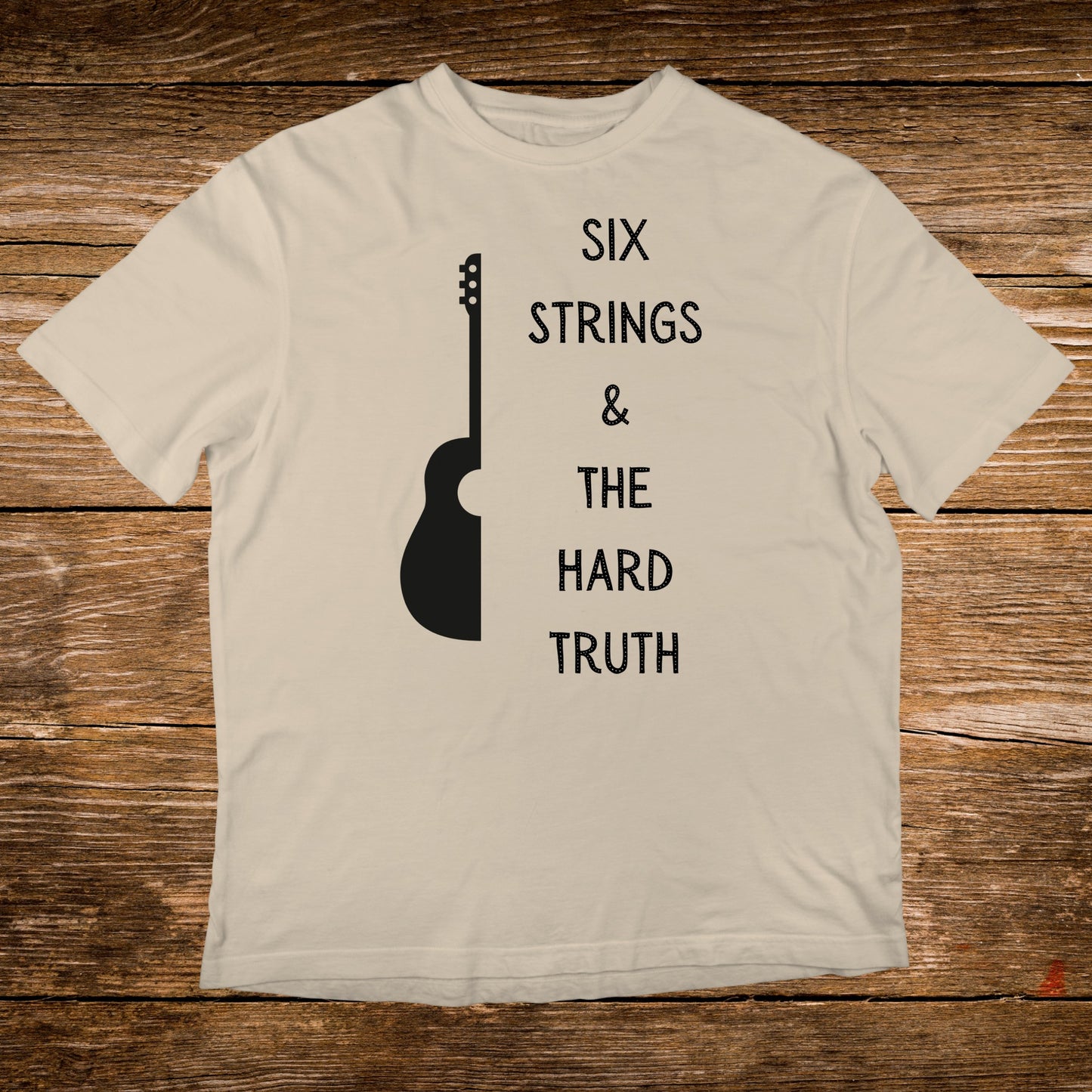 Cream t-shirt with black text "SIX STRINGS & THE HARD TRUTH" and guitar silhouette.