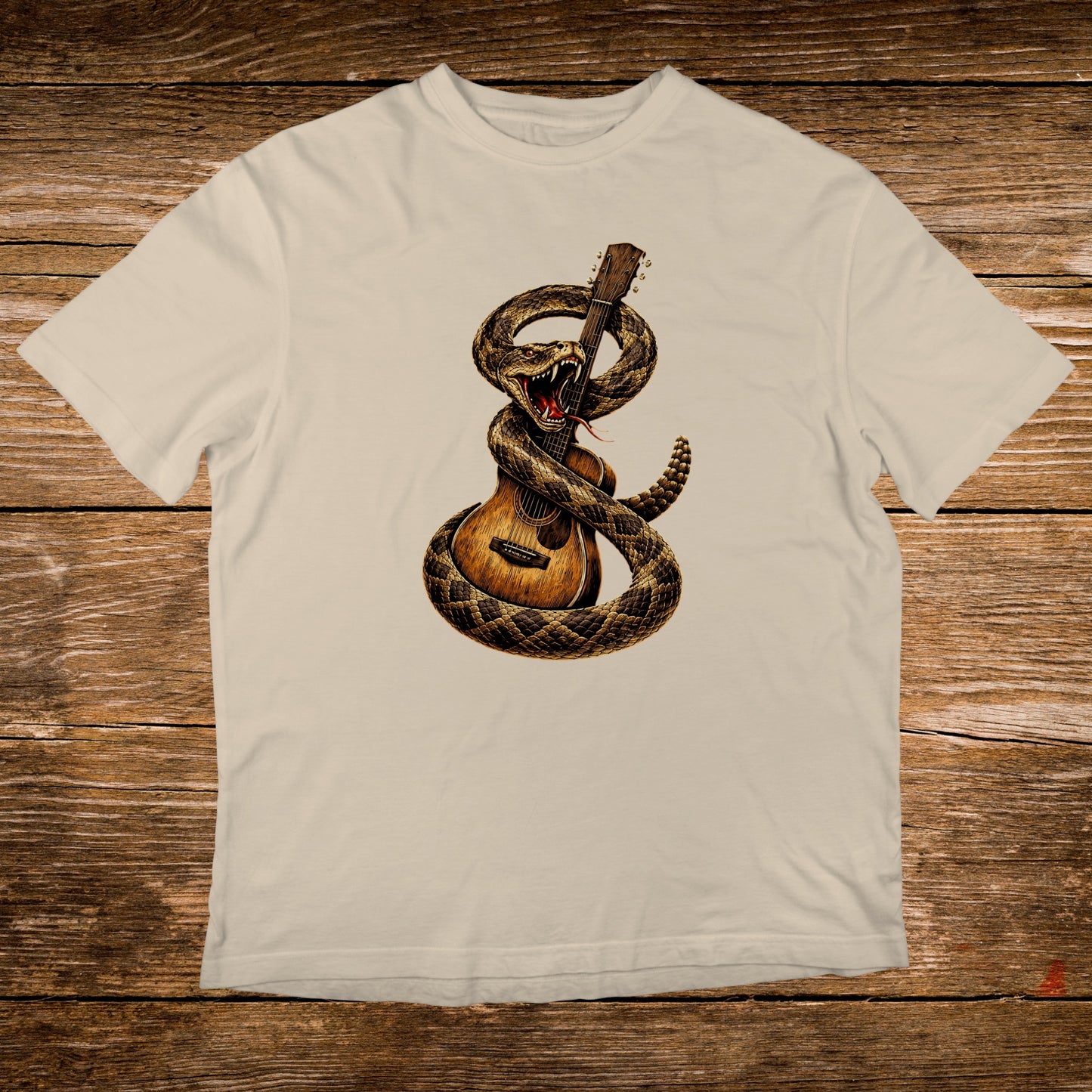 Rattlesnake coiled around acoustic guitar on a cream t-shirt.