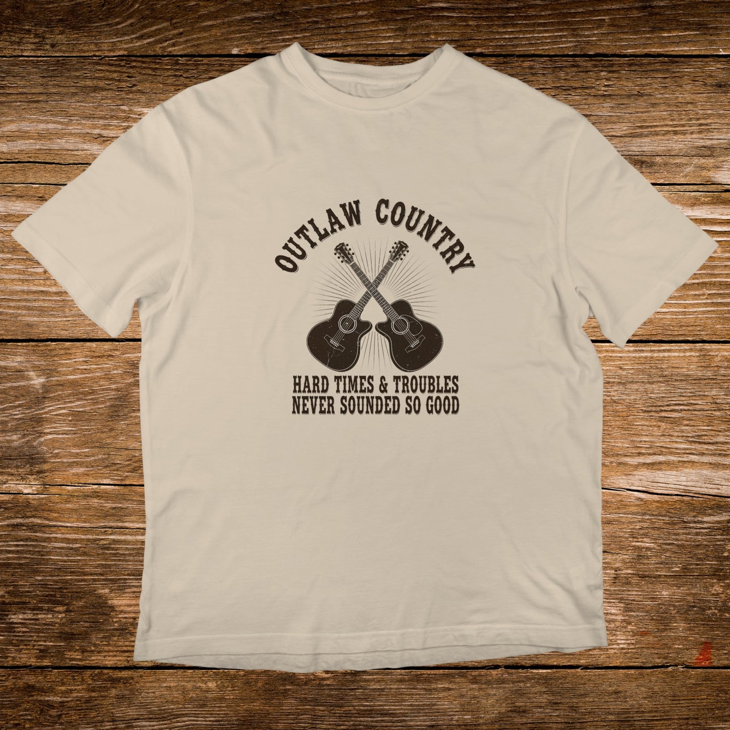 Cream t-shirt with crossed guitars and "Outlaw Country" text.