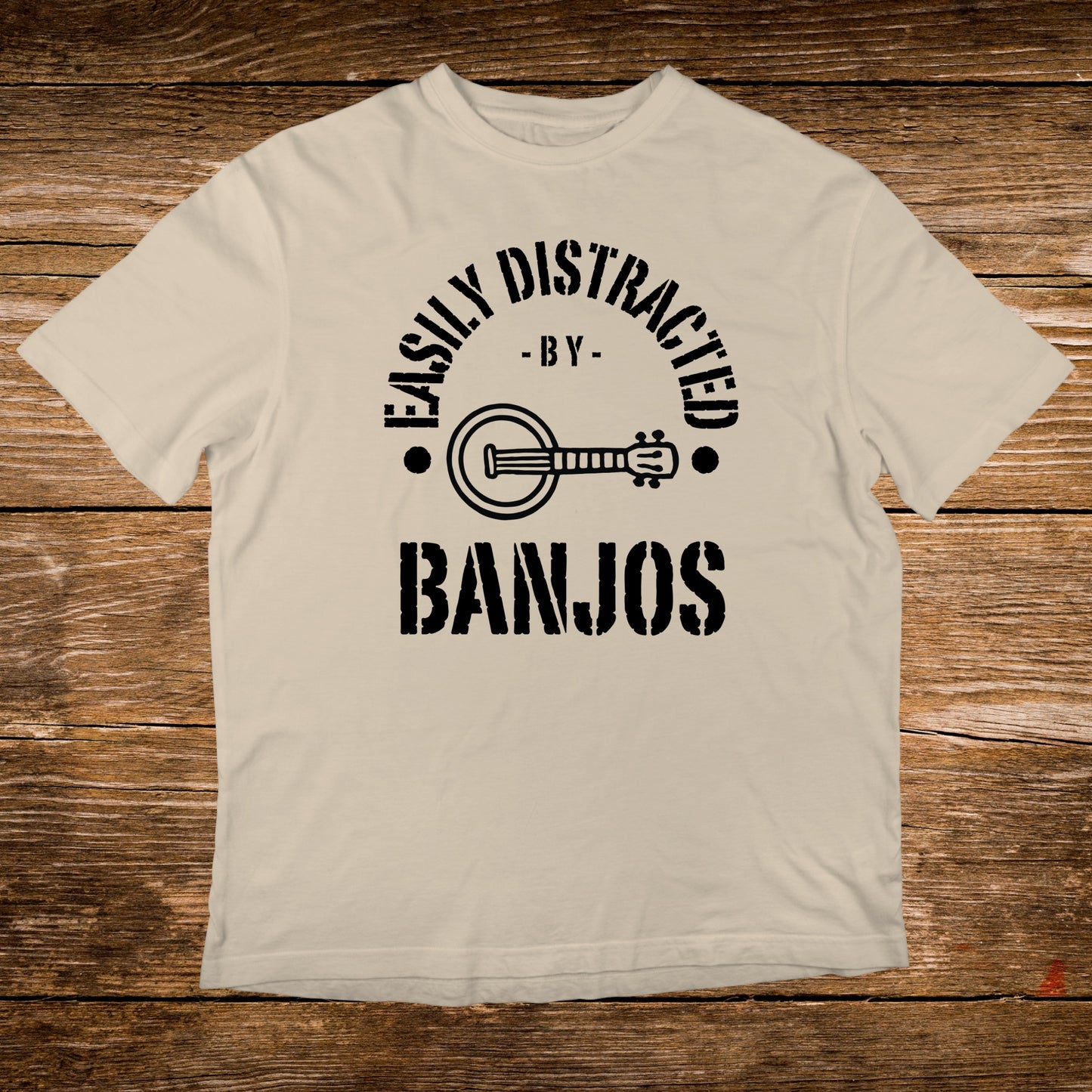 Cream t-shirt with black text "Easily Distracted By Banjos" and banjo graphic.