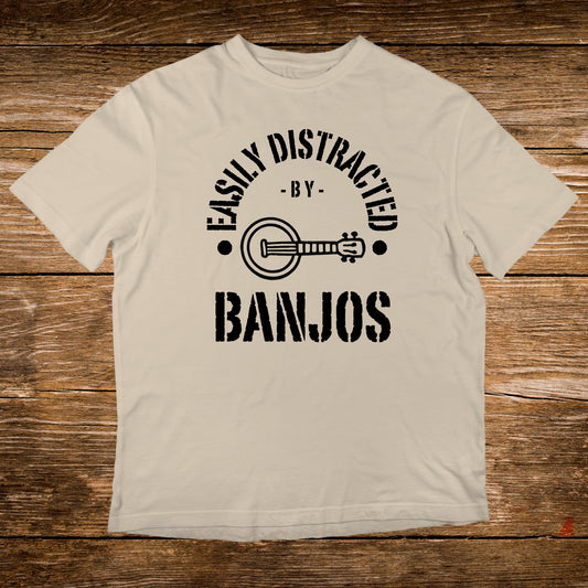 Cream t-shirt with black text "Easily Distracted By Banjos" and banjo graphic.