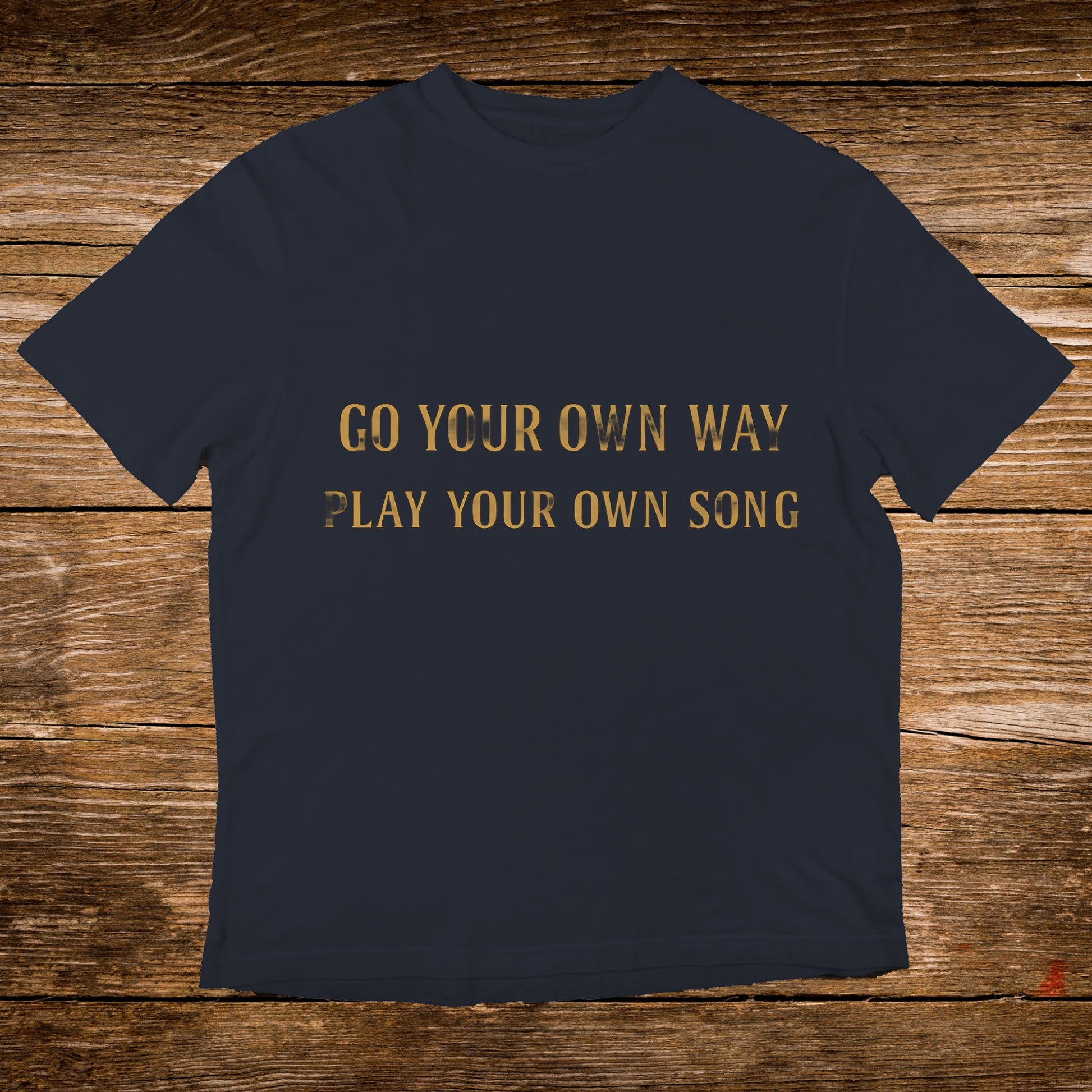 Dark blue t-shirt with gold text: "GO YOUR OWN WAY PLAY YOUR OWN SONG".