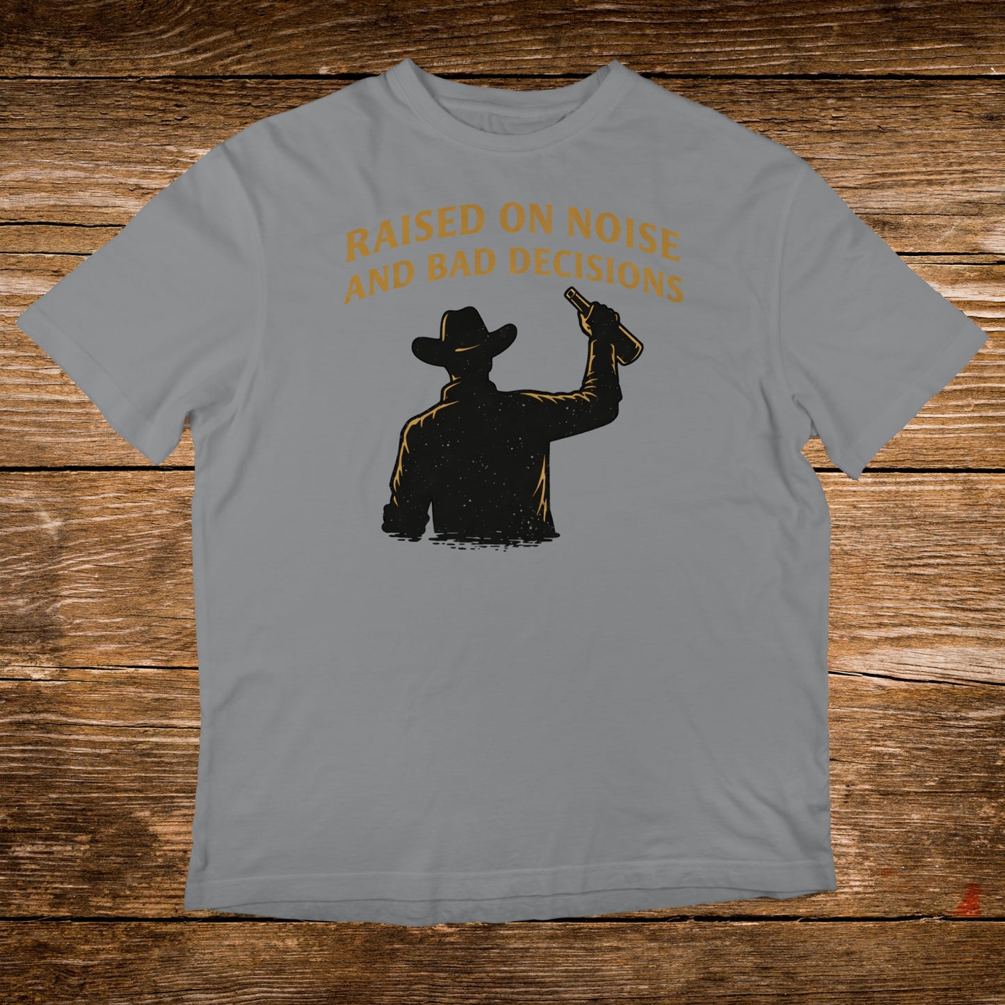 Cowboy silhouette raising bottle with text "Raised on noise and bad decisions".