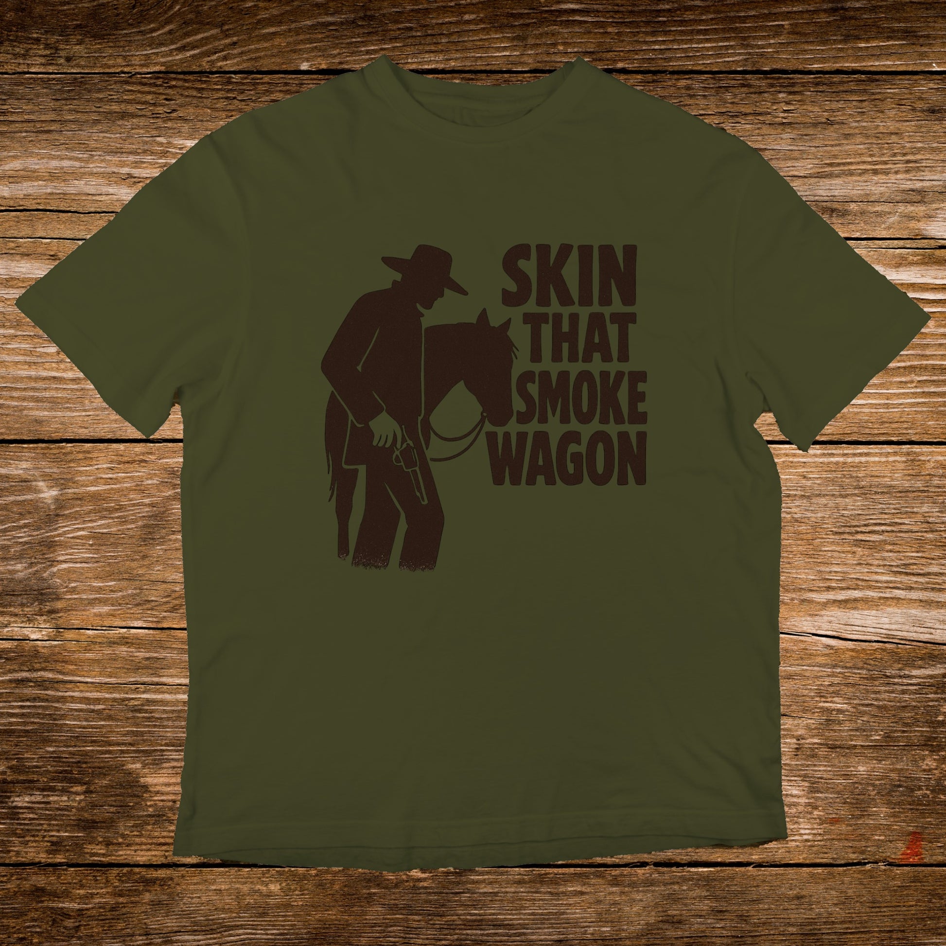 Olive green t-shirt with cowboy silhouette and "SKIN THAT SMOKE WAGON" text.