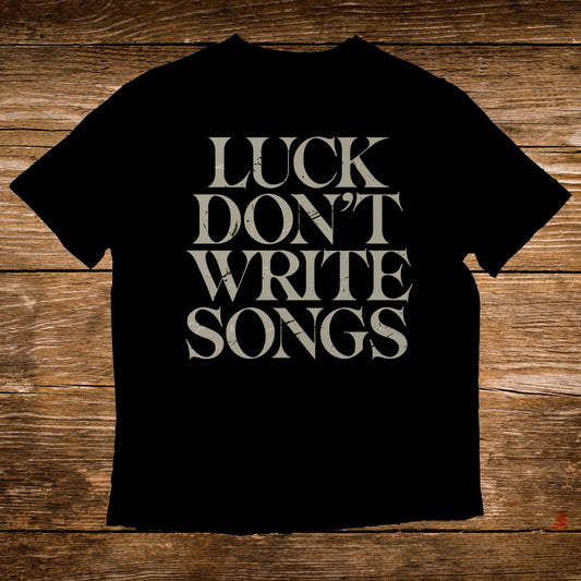 Black t-shirt with "LUCK DON'T WRITE SONGS" text in distressed white font.