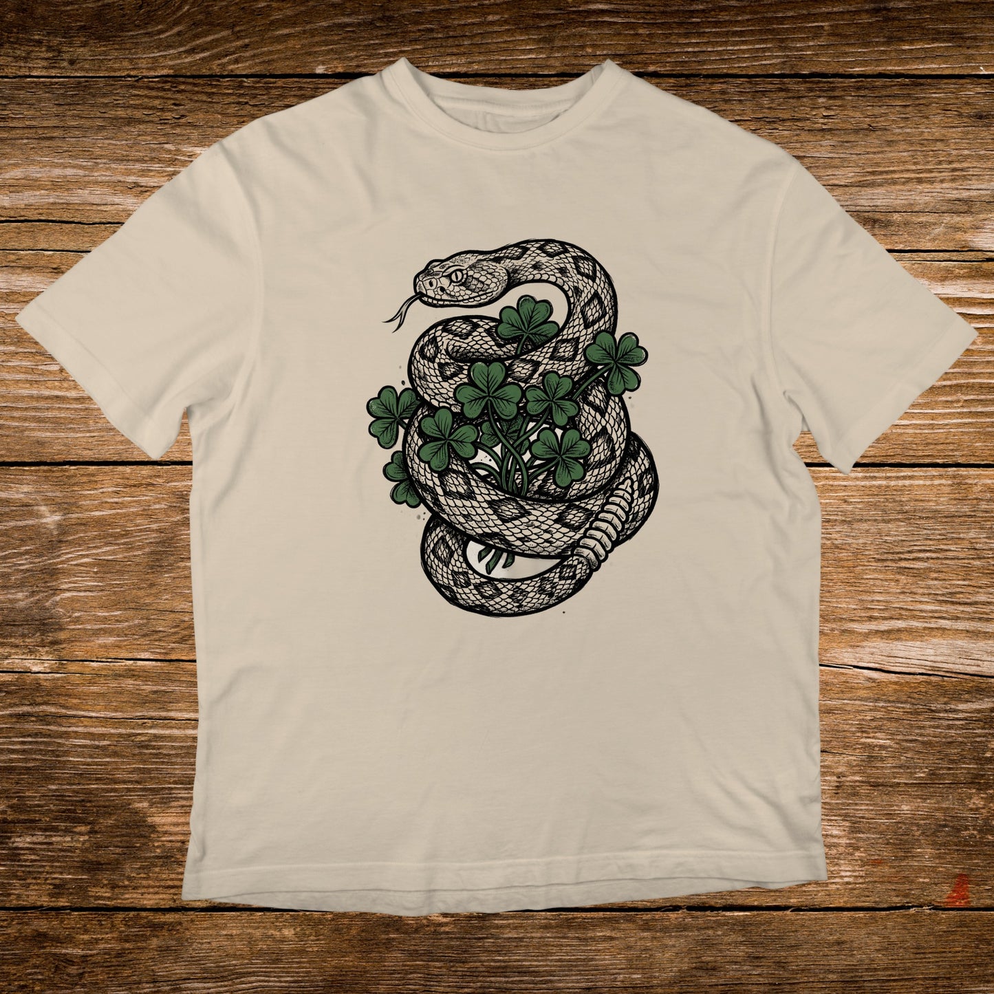 Cream t-shirt with a coiled snake around clover leaves.