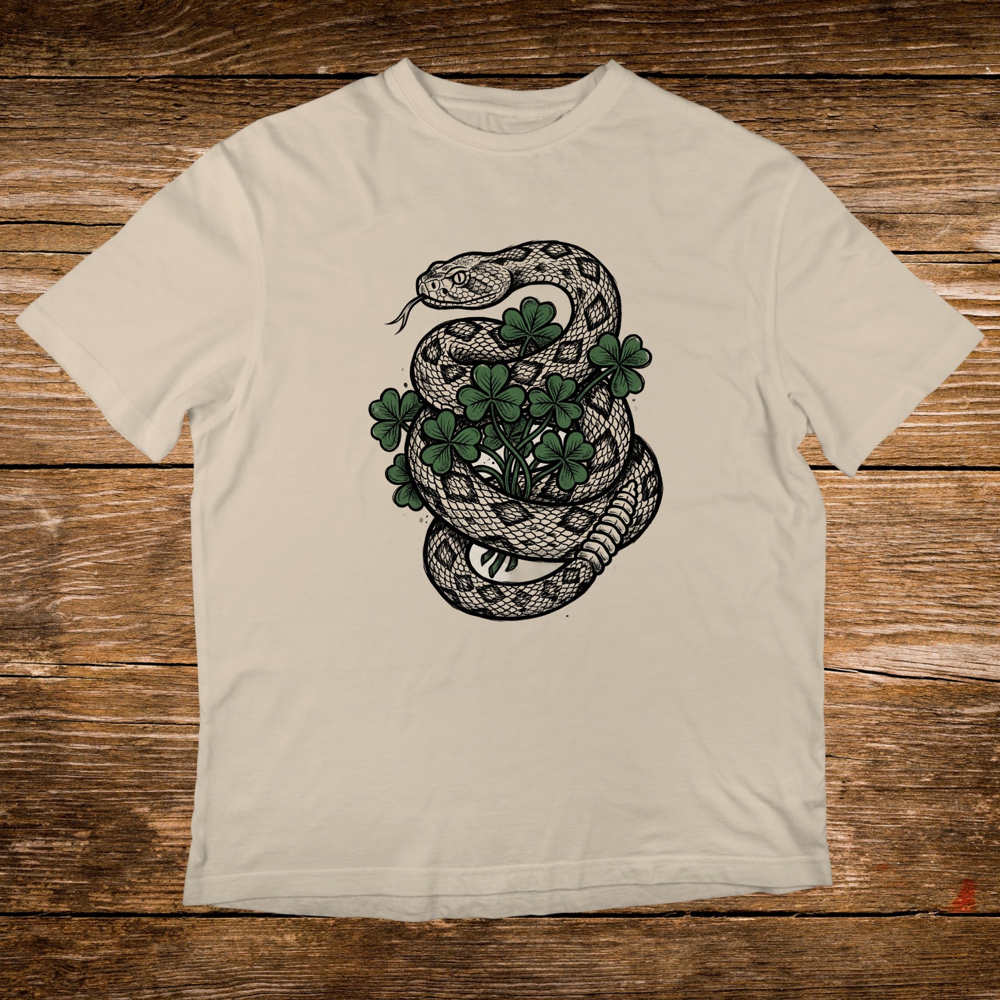 Cream t-shirt with a coiled snake around clover leaves.