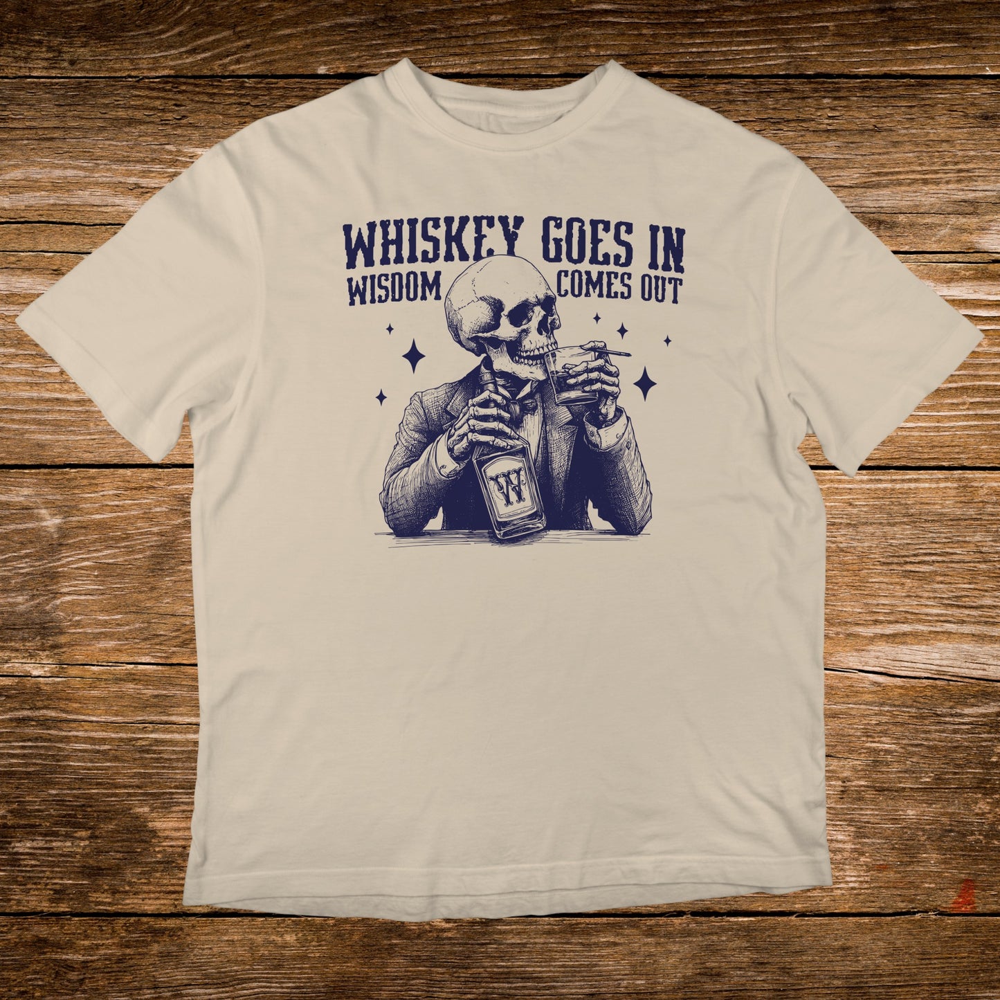 T-shirt graphic of a skeleton in a suit drinking whiskey, text reads "Whiskey goes in, wisdom comes out."