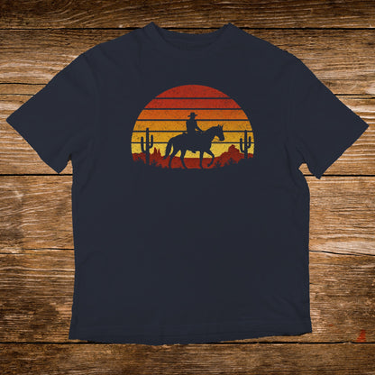 Sunset graphic with cowboy on horseback and desert cacti on navy t-shirt.
