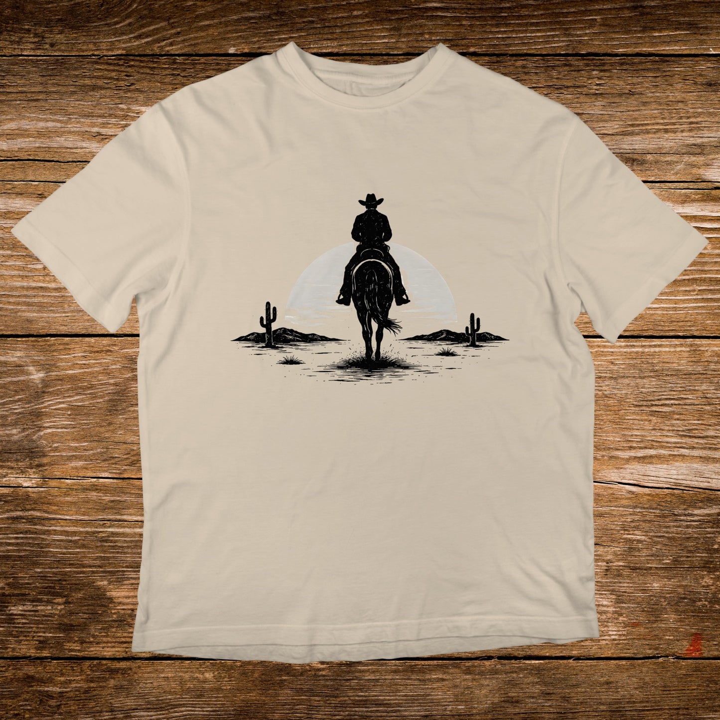 Silhouette of a cowboy on horseback in a desert landscape.