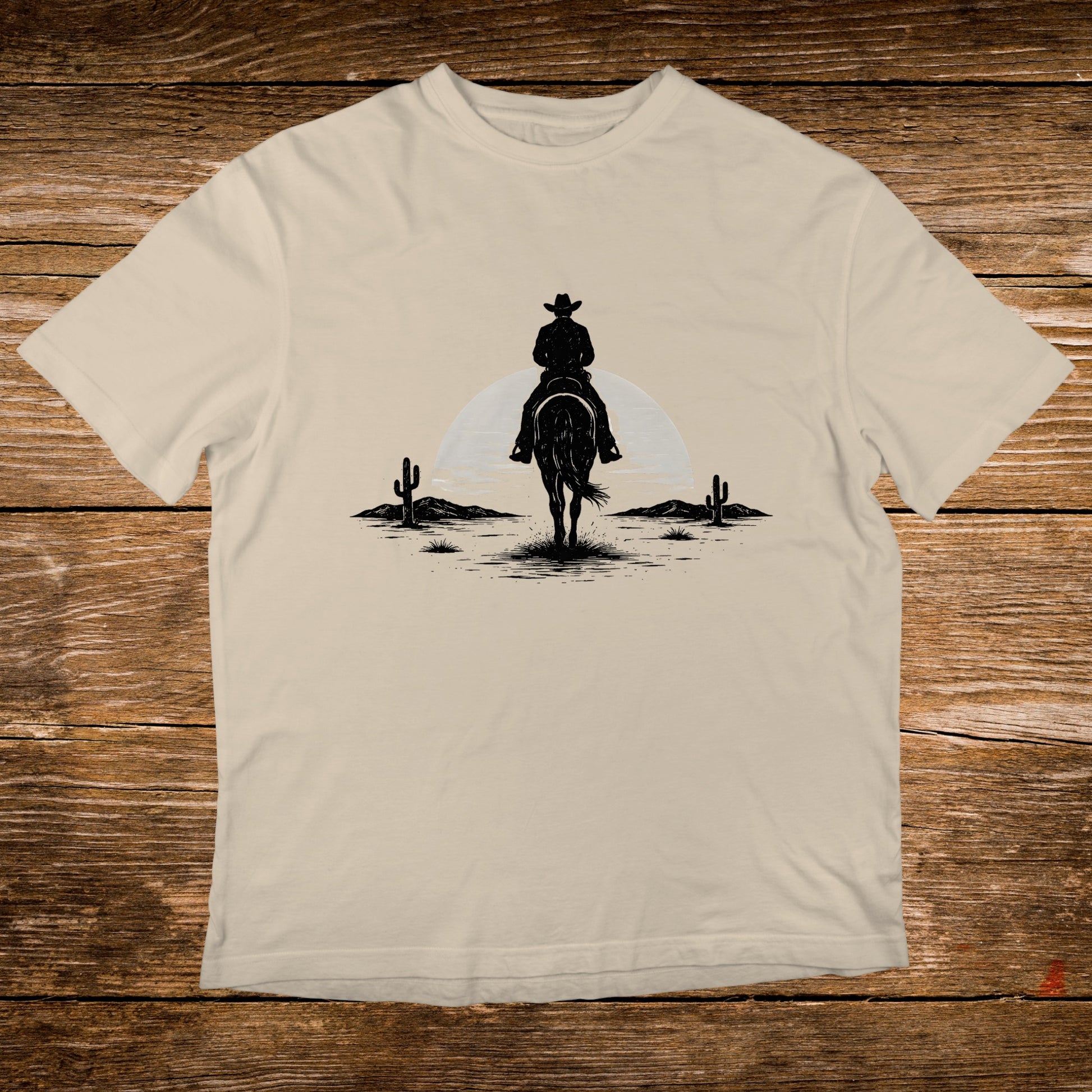 Silhouette of a cowboy on horseback in a desert landscape.