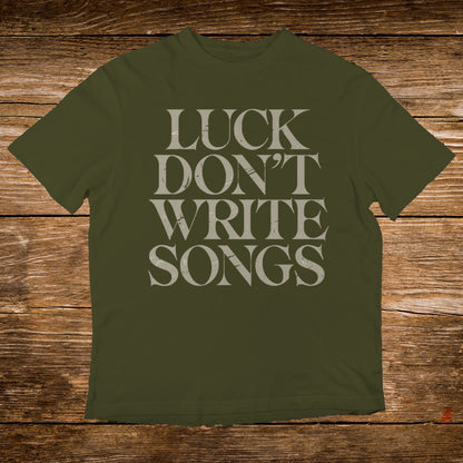 Olive t-shirt with "LUCK DON'T WRITE SONGS" text in gray.
