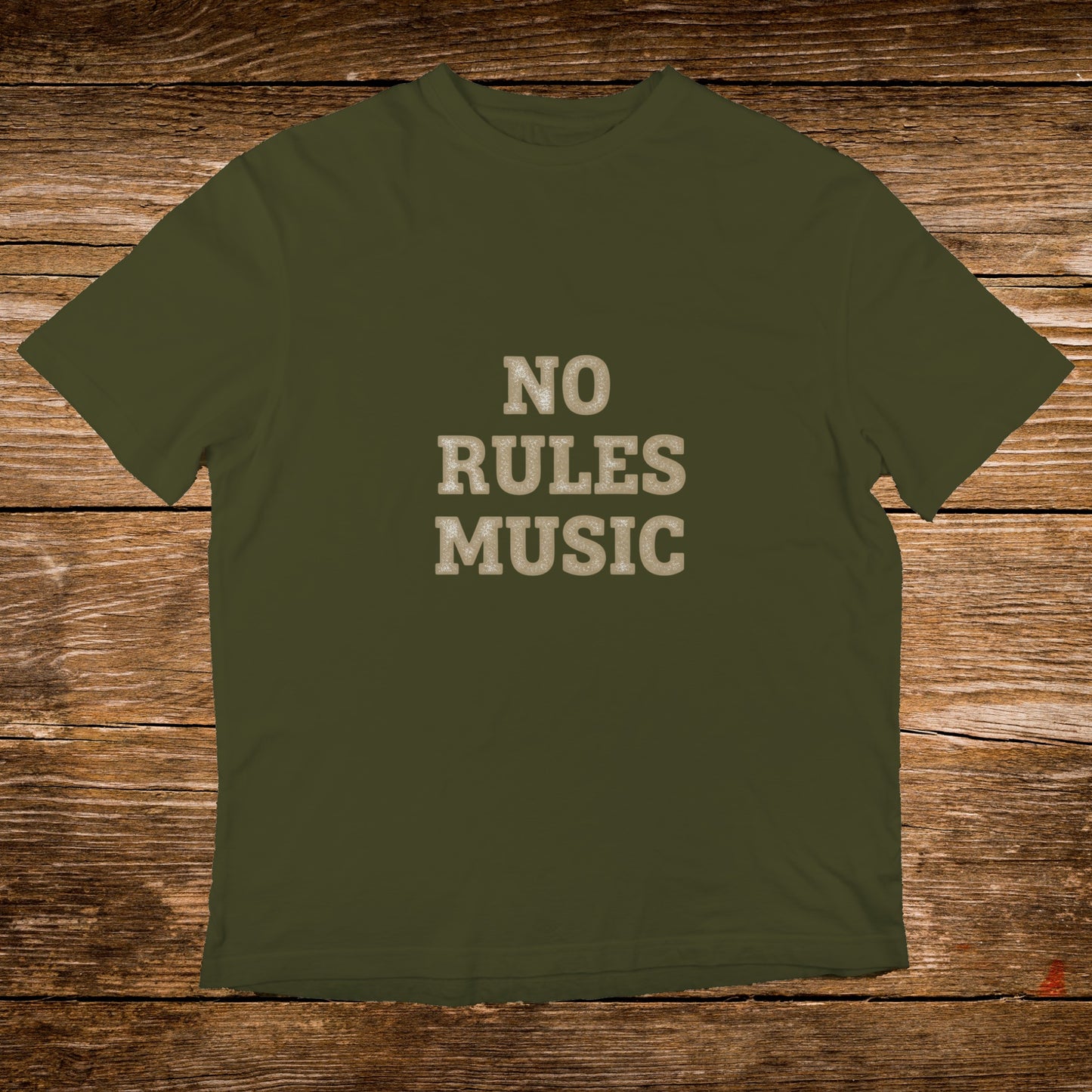Olive green t-shirt with "NO RULES MUSIC" text on a wooden background.