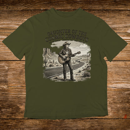 T-shirt with illustration of woman playing guitar on desert road, "Daughter of the Cosmic Cowboys" text.