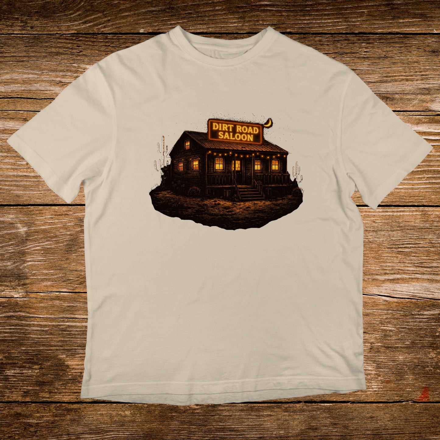 T-shirt graphic: "Dirt Road Saloon" illuminated neon sign above a rustic building.