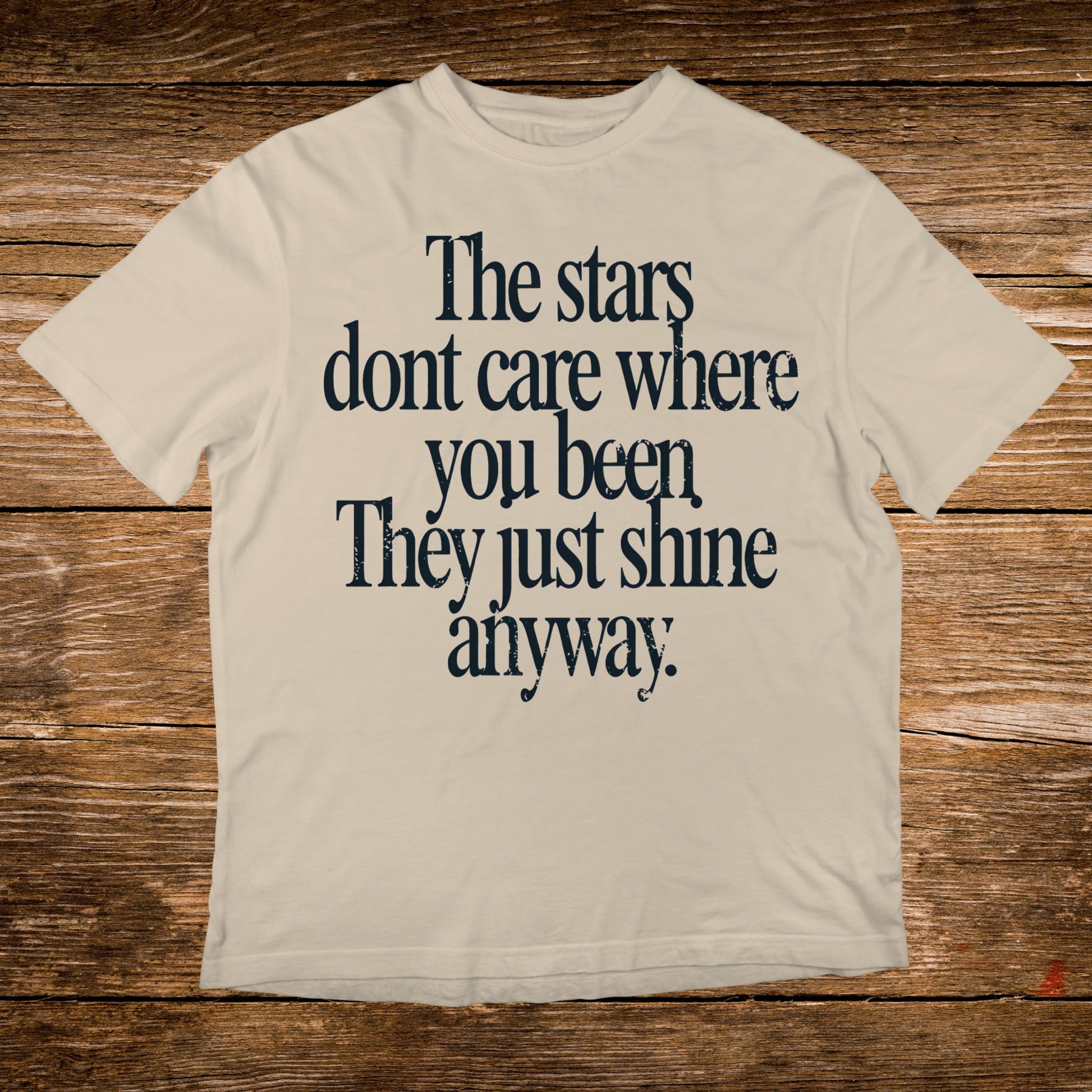 Cream t-shirt with "The stars dont care where you been. They just shine anyway." text.