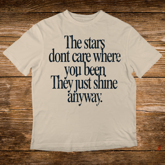 Cream t-shirt with "The stars dont care where you been. They just shine anyway." text.