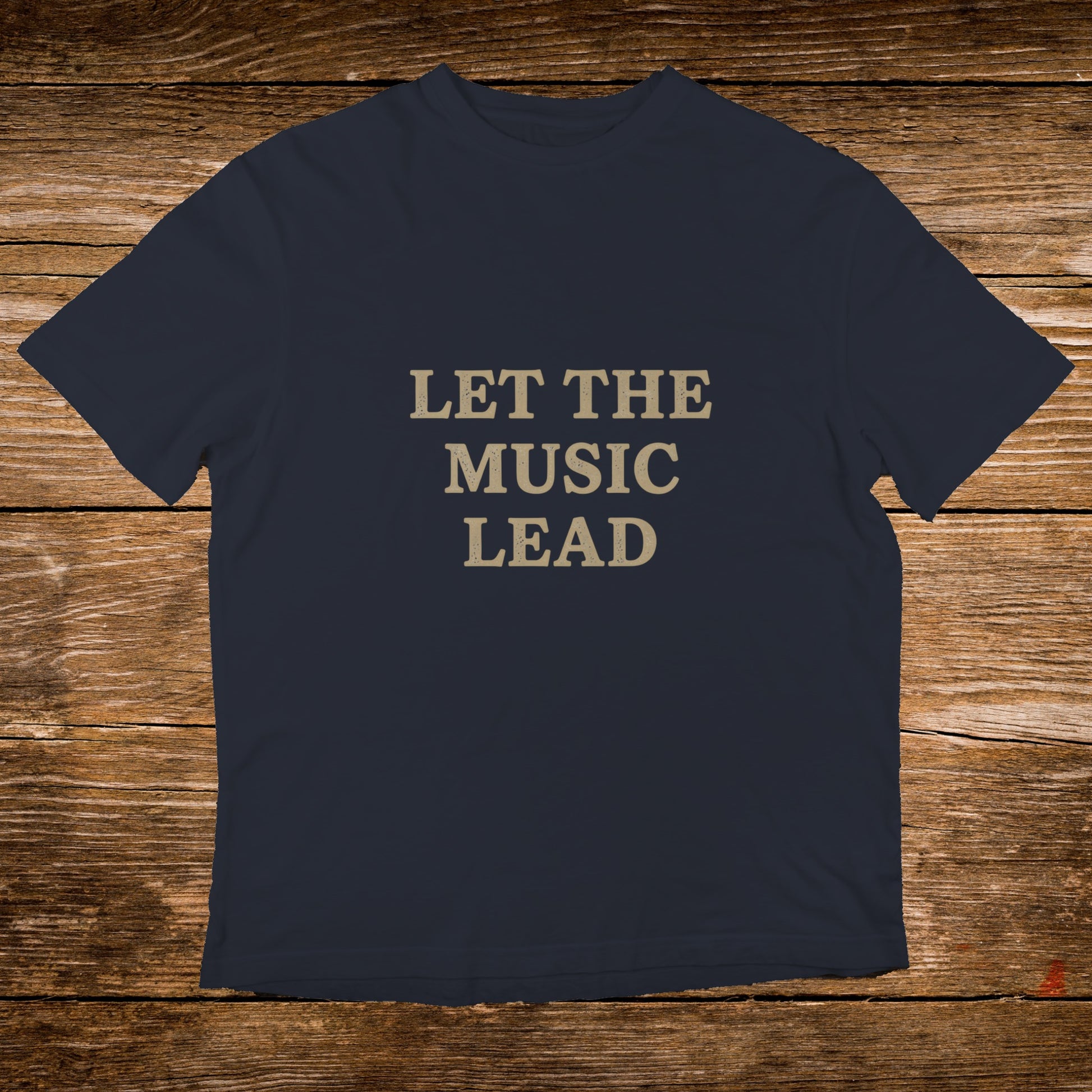 Navy t-shirt with "LET THE MUSIC LEAD" text in tan letters.