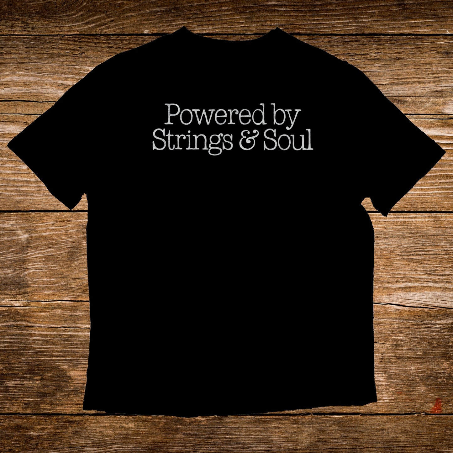 Black t-shirt with white text "Powered by Strings & Soul".