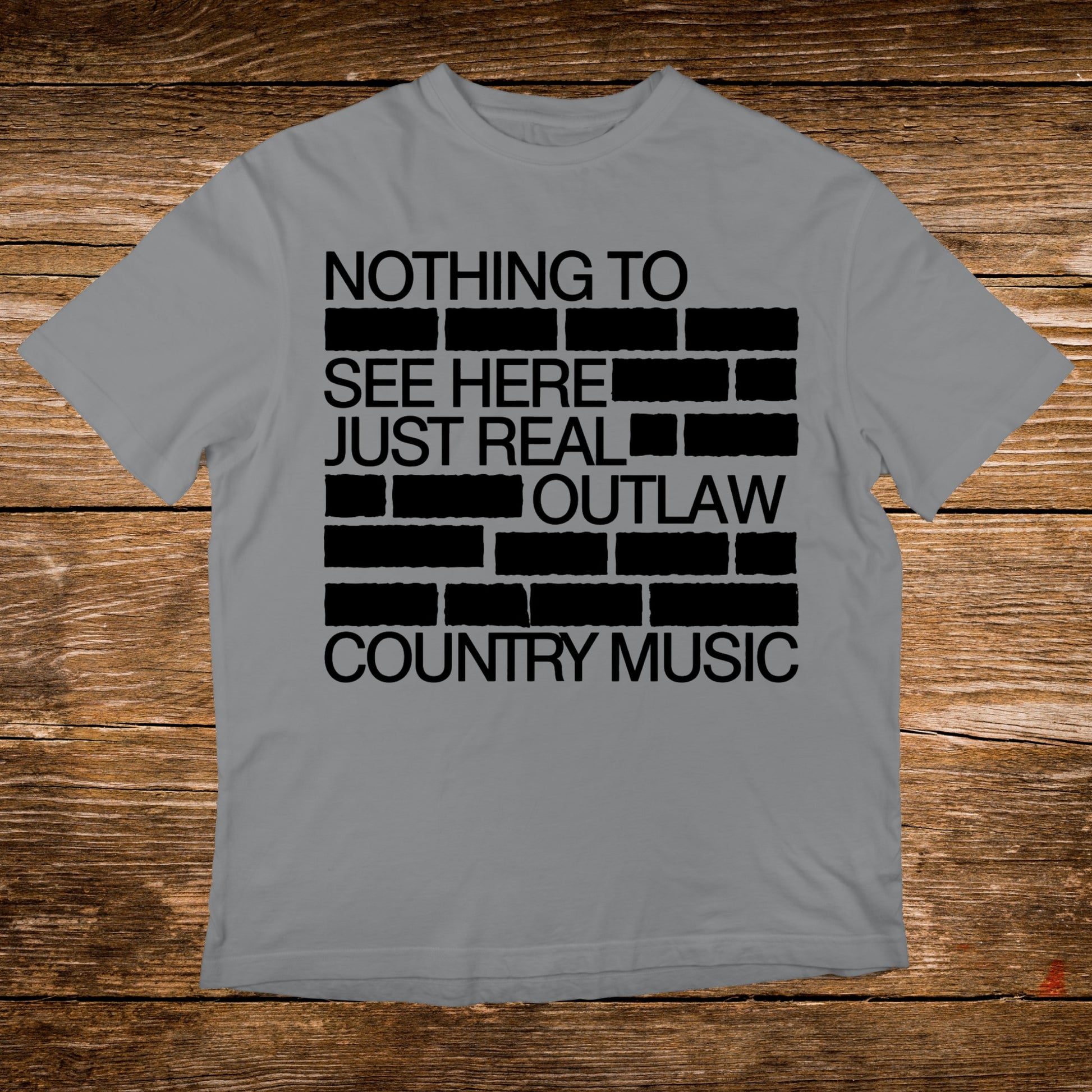 Grey t-shirt with black brick pattern text: "NOTHING TO SEE HERE JUST REAL OUTLAW COUNTRY MUSIC."