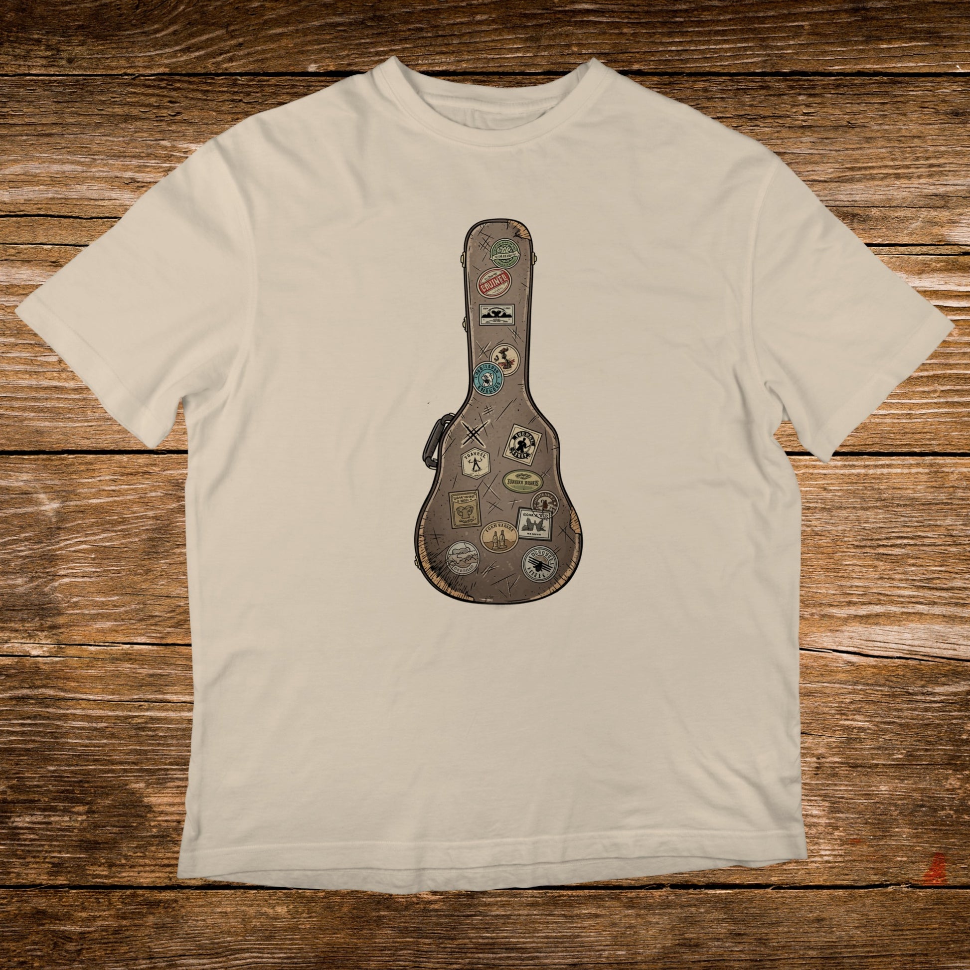 Cream t-shirt with a vintage guitar case design adorned with travel stickers.