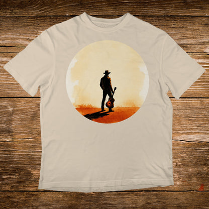 Man in cowboy hat holding acoustic guitar in sunlit desert landscape.