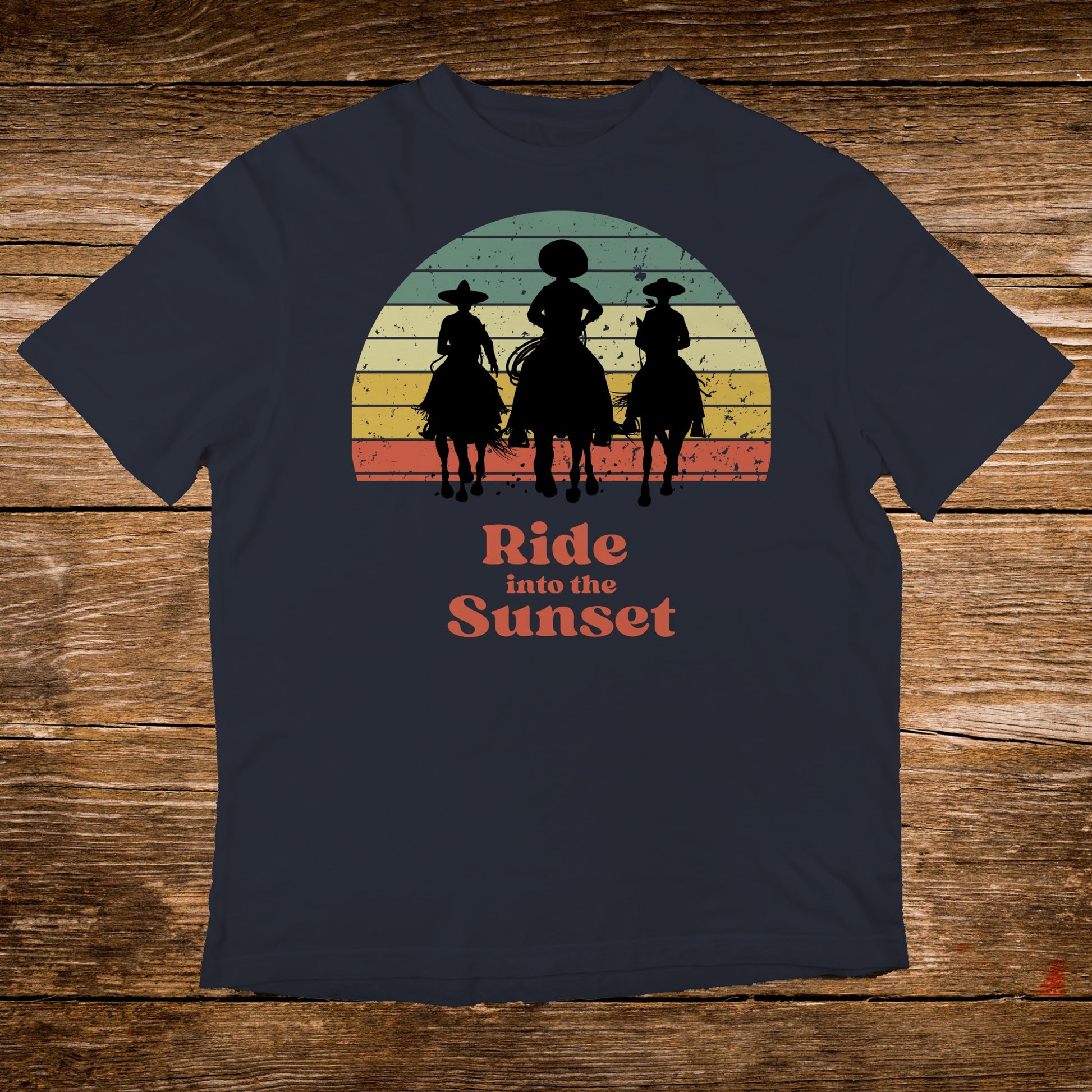 T-shirt with a graphic of three cowboys riding horses against a sunset.