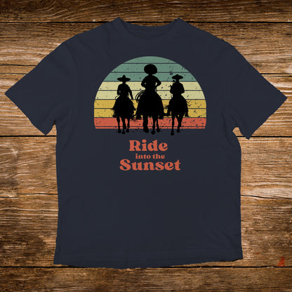 T-shirt with a graphic of three cowboys riding horses against a sunset.