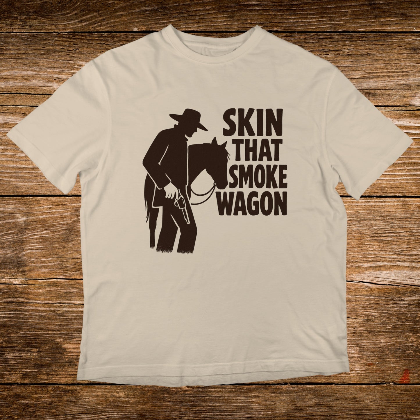 Light tan t-shirt with silhouette of cowboy and horse, text "SKIN THAT SMOKE WAGON".