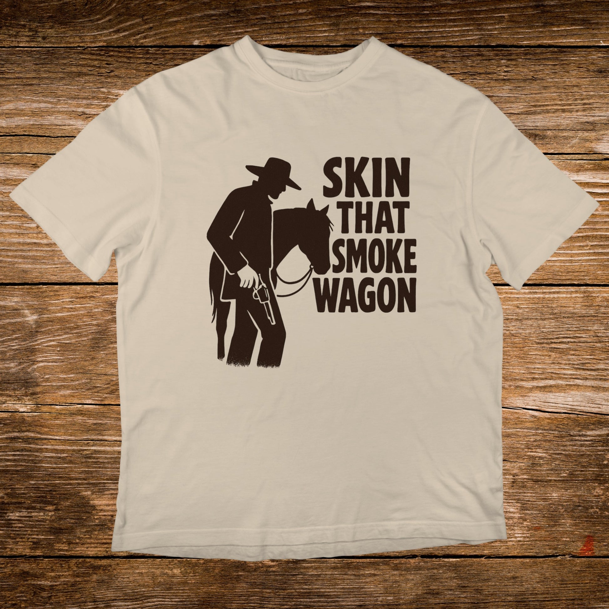 Light tan t-shirt with silhouette of cowboy and horse, text "SKIN THAT SMOKE WAGON".