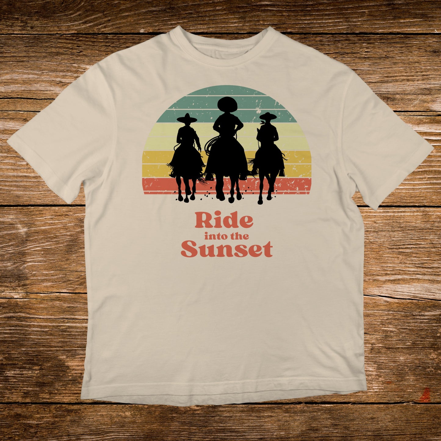T-shirt with sunset graphic of three horseback riders and text "Ride into the Sunset".