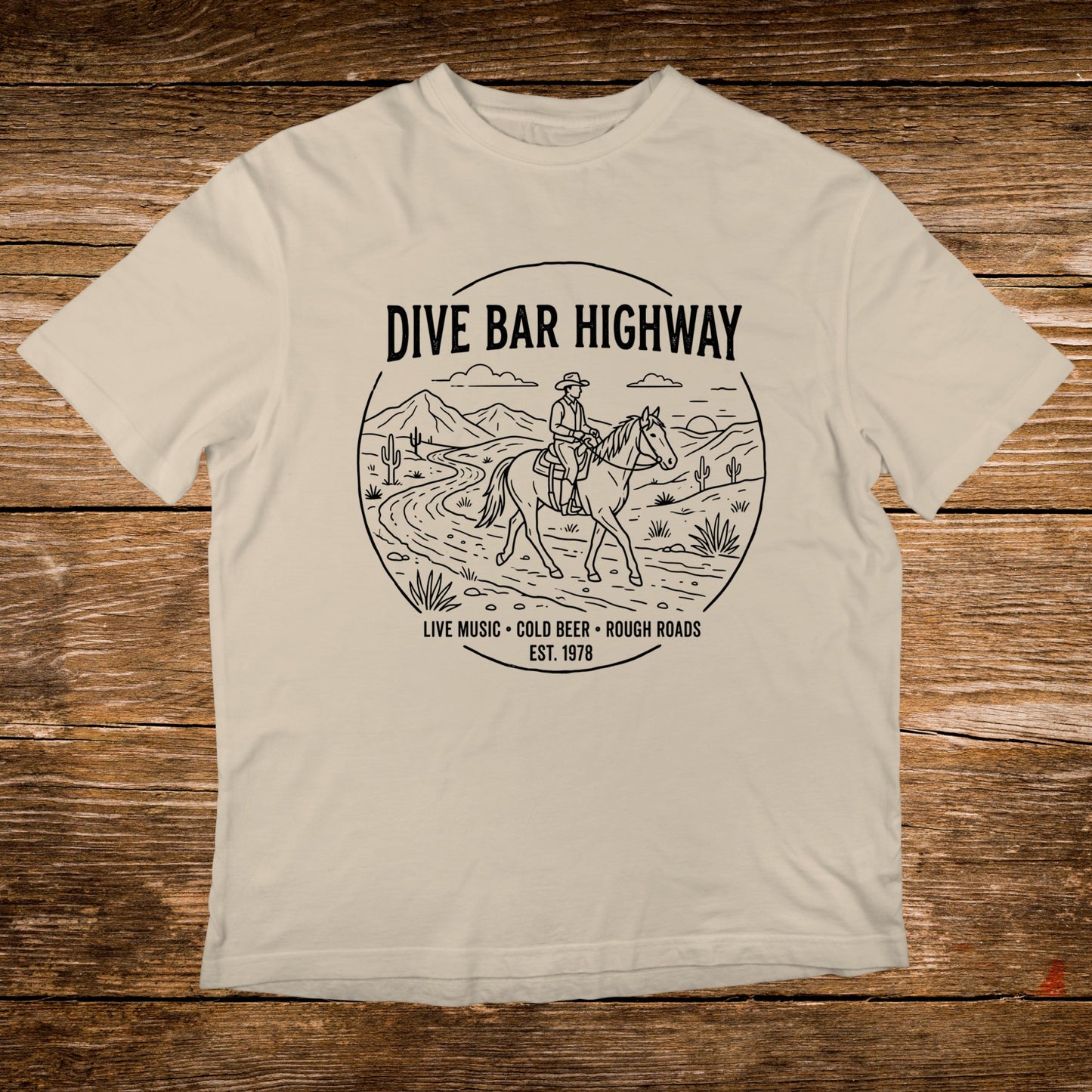 T-shirt with "DIVE BAR HIGHWAY" and horse rider graphic, "LIVE MUSIC COLD BEER ROUGH ROADS EST. 1978".
