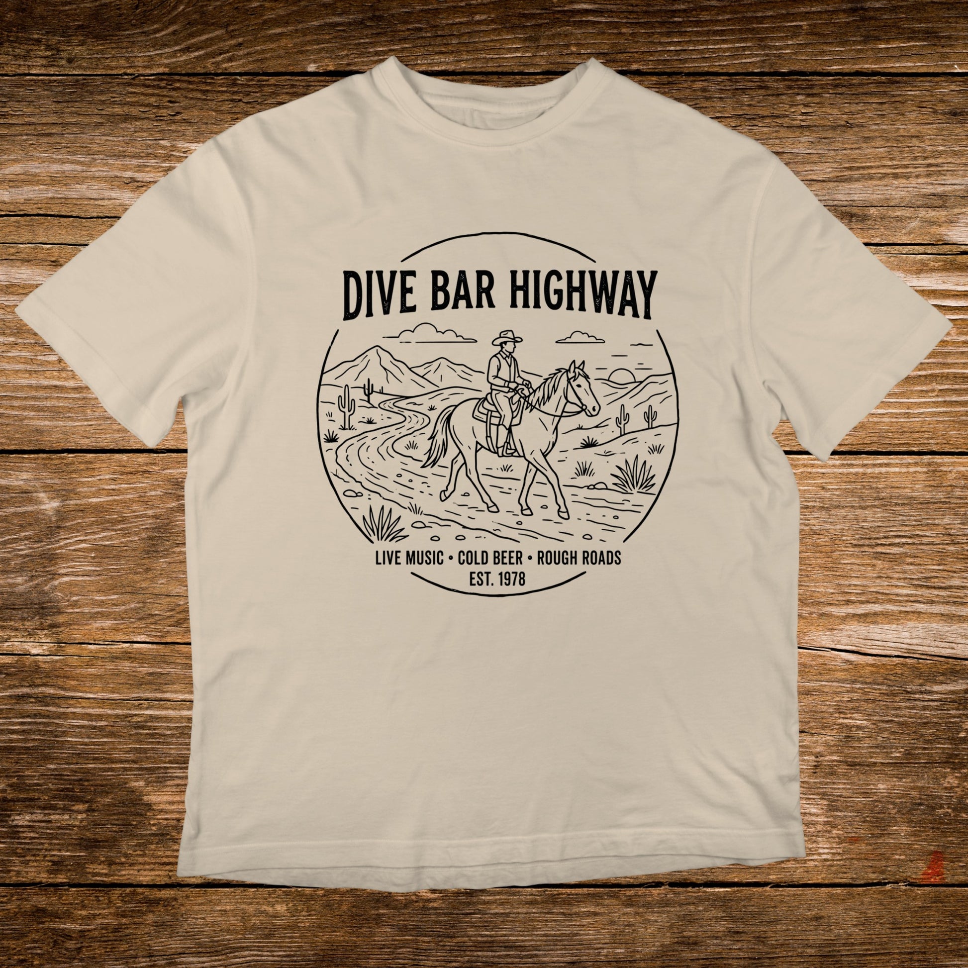 T-shirt with "DIVE BAR HIGHWAY" and horse rider graphic, "LIVE MUSIC COLD BEER ROUGH ROADS EST. 1978".
