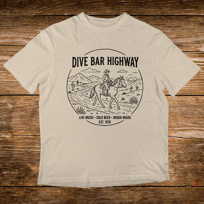 T-shirt with "DIVE BAR HIGHWAY" and horse rider graphic, "LIVE MUSIC COLD BEER ROUGH ROADS EST. 1978".