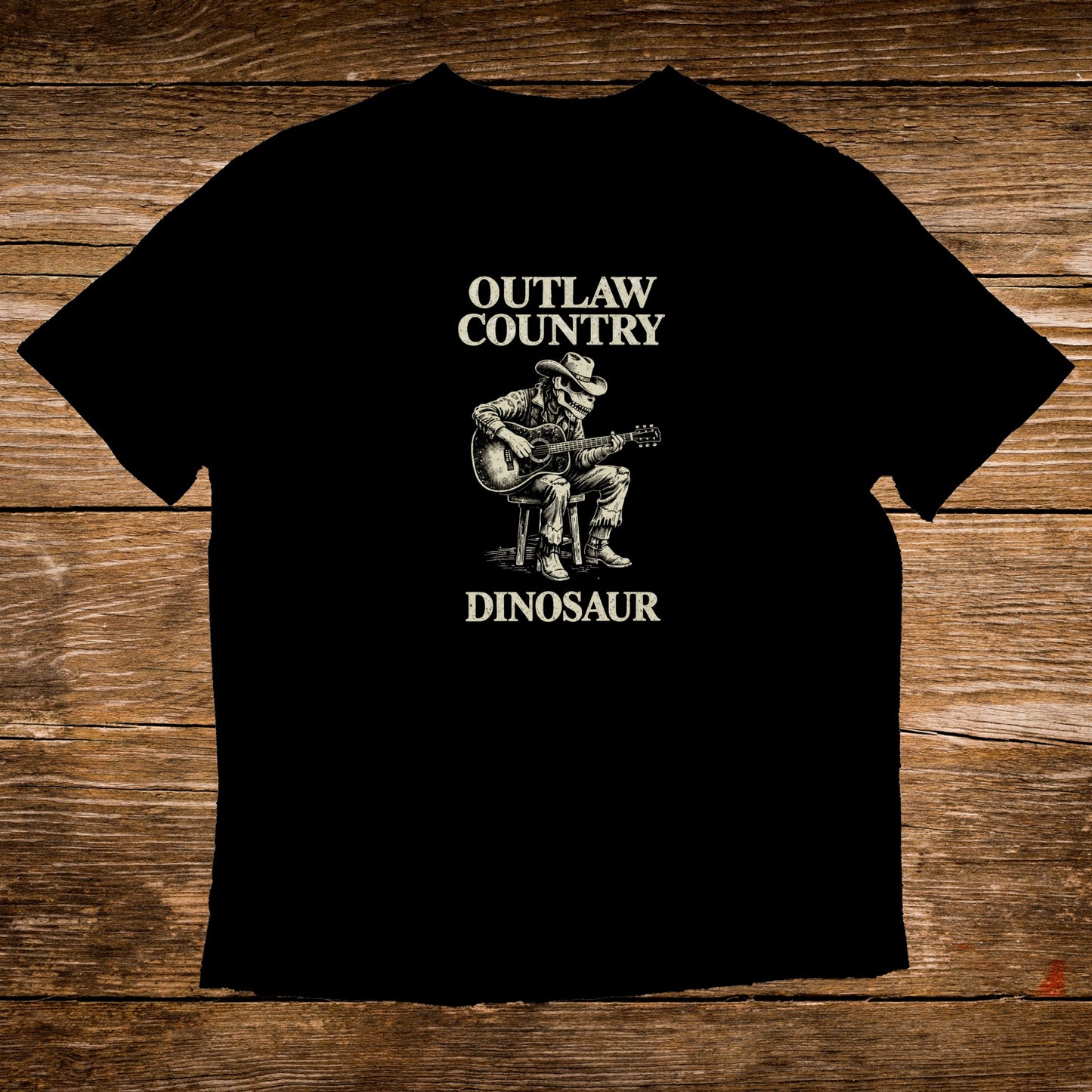 Black t-shirt with a graphic of a cowboy dinosaur playing guitar.